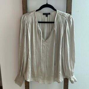 Banana Republic champagne colored blouse with ties and smocked cuff on sleeve.